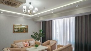 A modern living room with a sofa, armchairs, a coffee table, and a painting on the wall. - Samarqand Darvoza (Bukhara)