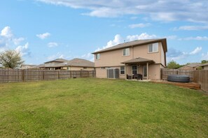 A two-story house with a fenced backyard, a patio, and a large inflatable pool. - Kitchen Foosball Fenced Yard Parking (Kyle)