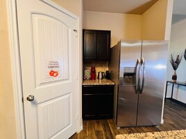 Una cocina con un refrigerador de acero inoxidable, una cafetera y un dispensador de agua.