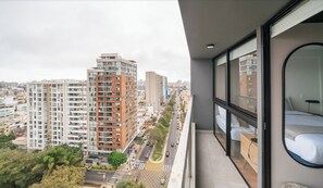 A high-rise building with multiple floors, a balcony with a bed, and a cityscape view. - Amazing View 3BR Apartment (Lince)