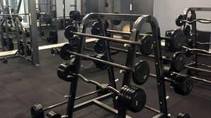 Ein Fitnessraum mit Gewichtheimbekleidung, darunter Hanteln und Gewichte.