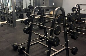 Ein Fitnessraum mit Gewichtheimbekleidung, darunter Hanteln und Gewichte.