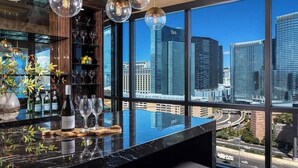 Eine Bar mit Blick auf die Stadt, eine Weinflasche und Gläser auf der Theke.