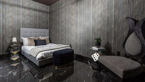 Ein modernes Schlafzimmer mit Bett, Nachttischen, einer Bank und einem einzigartigen Kunstwerk an der Wand.