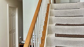 A staircase with wooden balusters and carpeted steps.