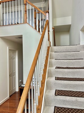 A staircase with wooden balusters and carpeted steps.