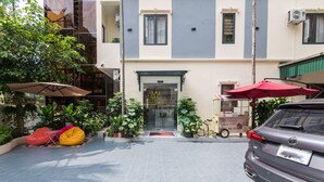 A building with a storefront, outdoor seating, and a parked car. - Aura Retreat Boutique Hotel Hanoi (Hanoi)