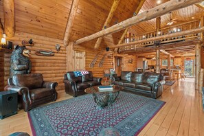 A log cabin interior with leather sofas, a glass coffee table, and a patterned rug. - Fabulous Luxury Log Home, 6BR/4BA Hot Tub, 3 Min Drive to Base (Ludlow)