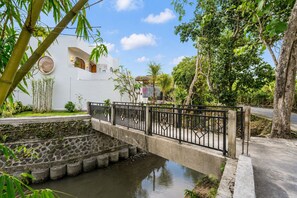 A white building with a stone water feature and a metal bridge. - 2BR Private Pool Villa Near Batu Bolong & La Brisa (Badung)