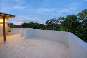 A rooftop terrace with a curved white wall, a potted plant, and a pergola structure. - 2BR Private Pool Villa Near Batu Bolong & La Brisa (Badung)