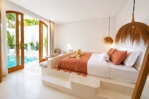Un dormitori modern amb llit, llum penjant i vista a una piscina.