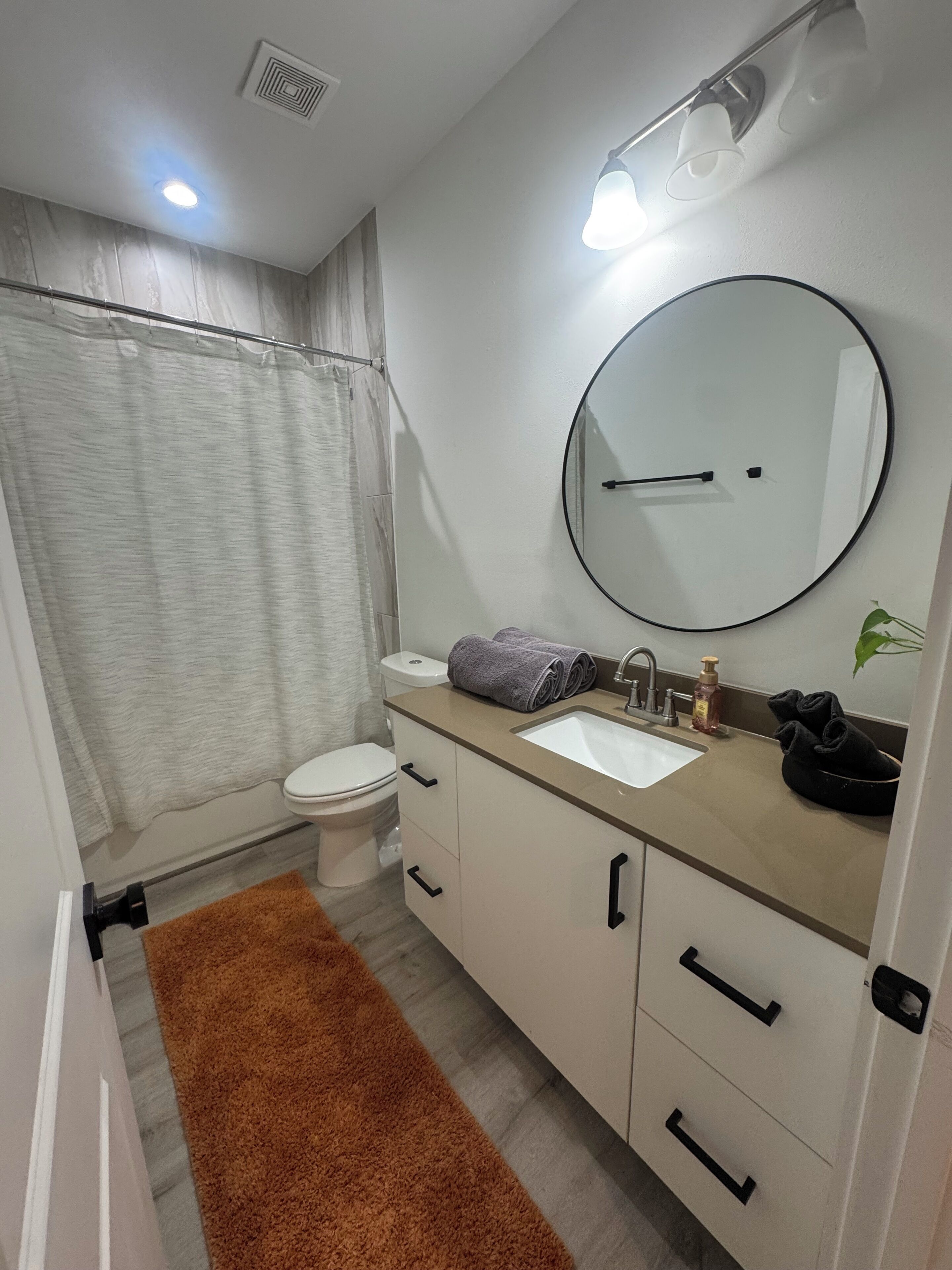 Ein Badezimmer mit Toilette, Waschbecken, Spiegel und Handtuchhalter.