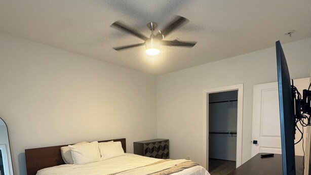 A bedroom with a bed, a ceiling fan, a dresser, and a television. - 3BR home w/ AC, parking & W/D near Galleria/ Downtown (Houston)