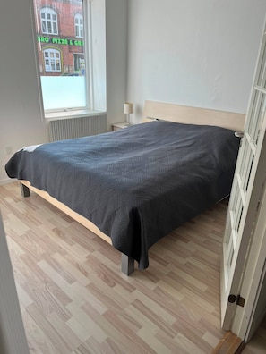 Ein Zimmer mit Bett, Fenster und Heizkörper.