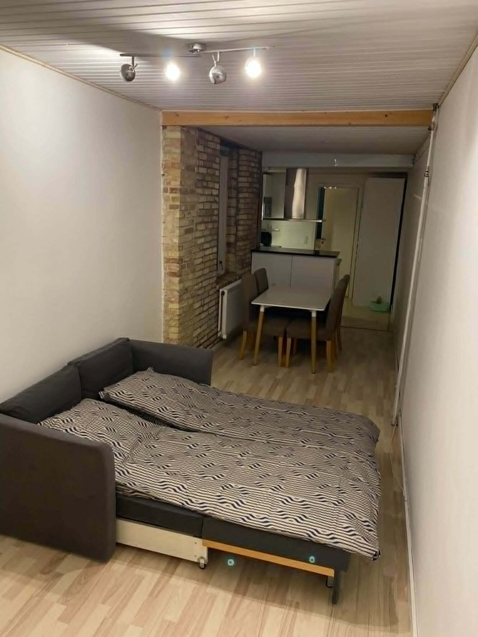 Habitación pequeña con cama, un escritorio y una silla.