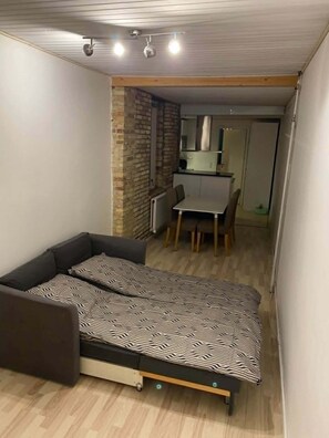 Habitación pequeña con cama, un escritorio y una silla.