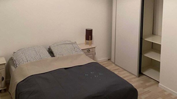 A bedroom with a bed, a nightstand, a bedside table, a wardrobe, and a closet. - Comfortable and centrally located home in Odense (Odense)