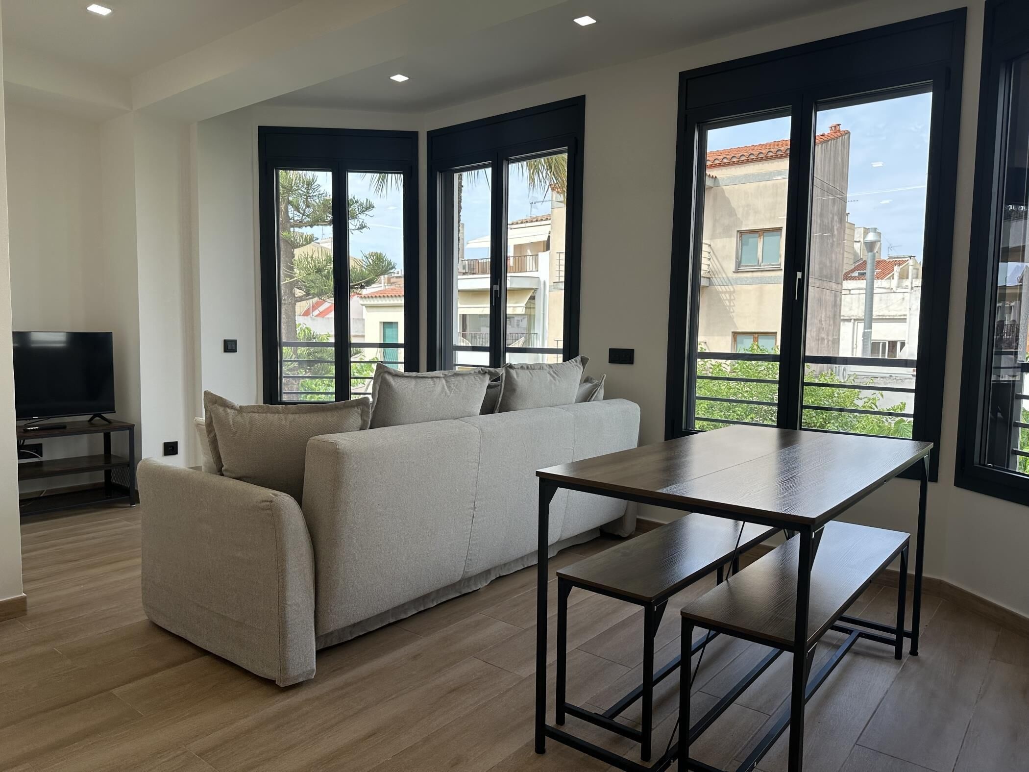 A modern living room with a sofa, a coffee table, and a TV.