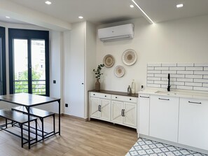 A modern kitchen with white cabinets, a wooden countertop, and a backsplash. - Apartment with A/C and terrace only 250m beach (Calella)