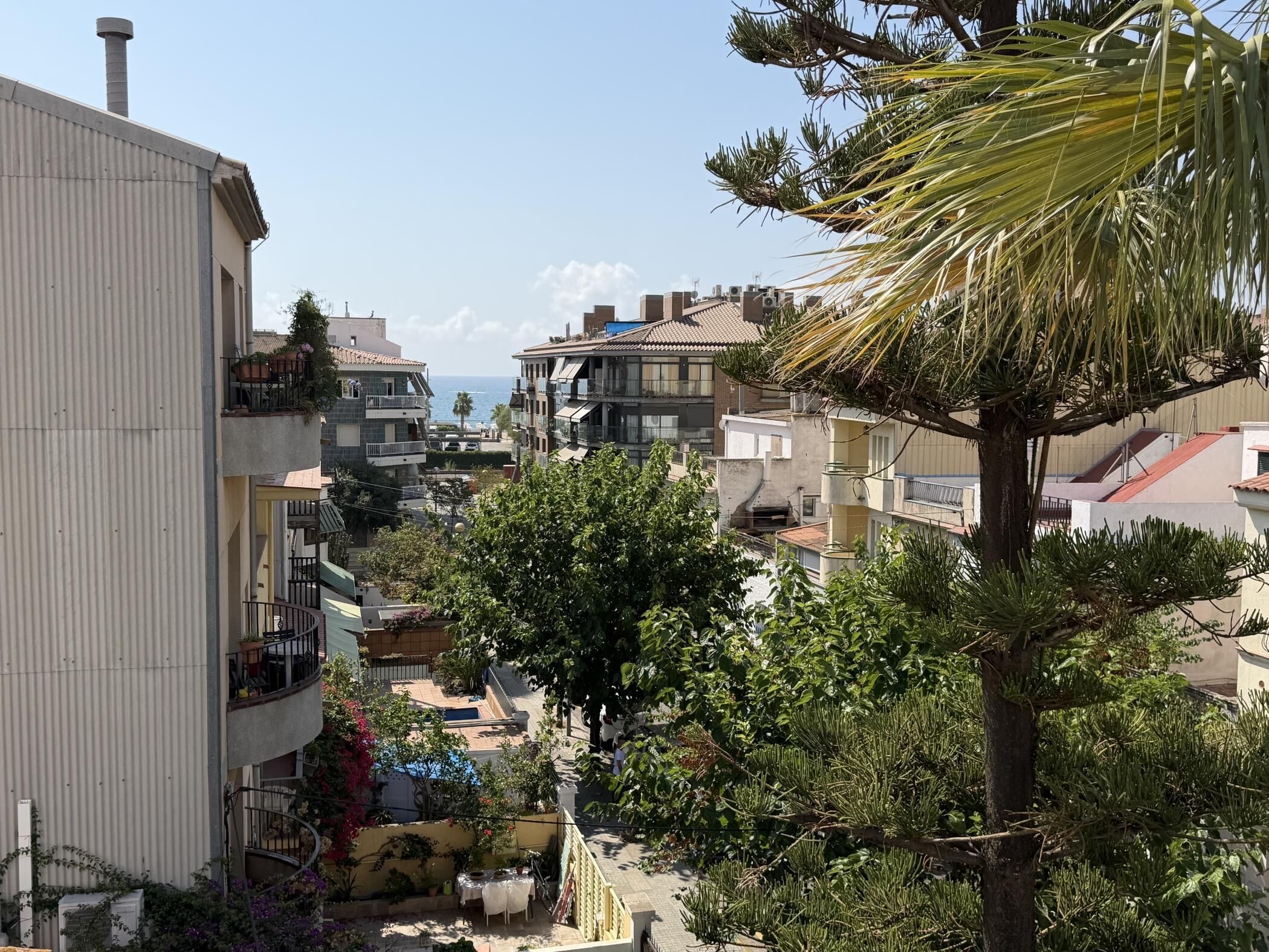 Un barrio residencial con edificios de varios pisos, balcones y vista al mar.