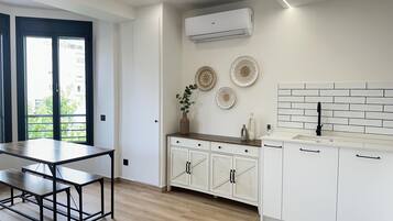A modern kitchen with white cabinets, a wooden countertop, and a backsplash.