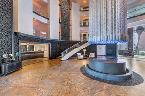 A spacious lobby with a central fountain, a staircase, and a reception desk. - Cabo Azul Resort - 2-bedroom/2-bath (San Jose Del Cabo)