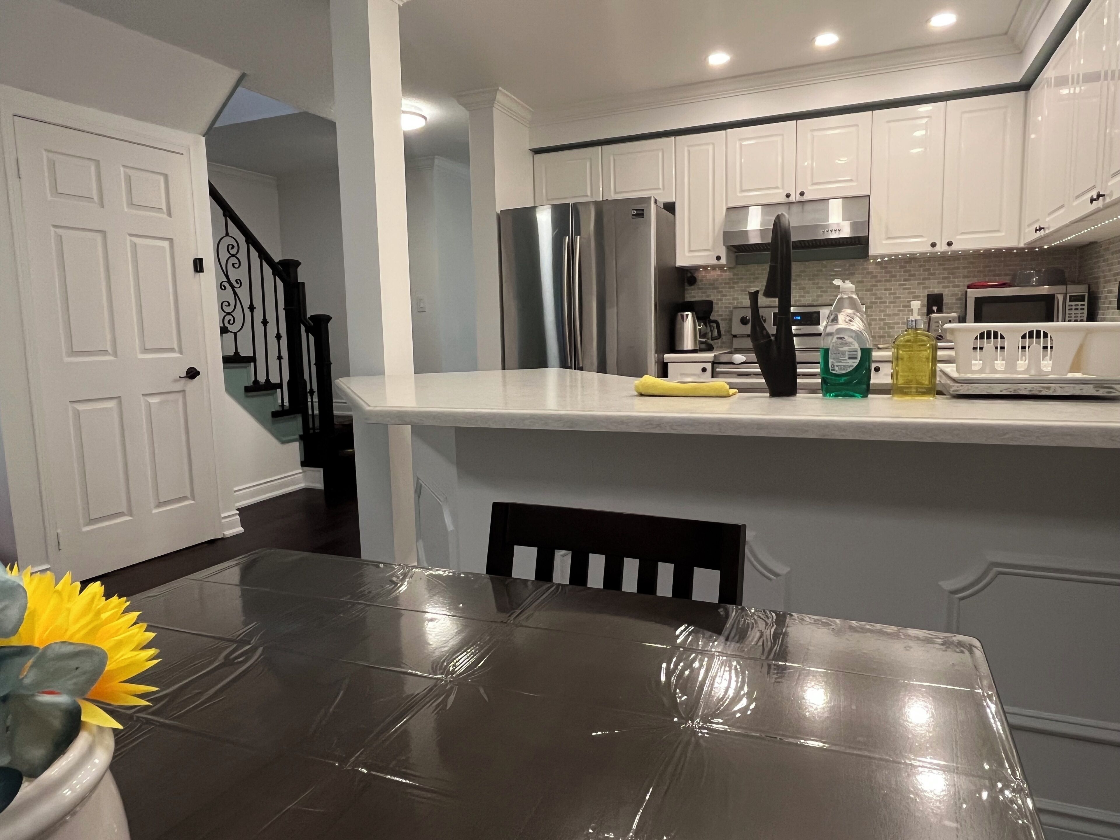 A modern kitchen with white cabinetry, stainless steel appliances, and a marble countertop.
