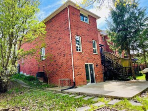 A red brick building with a staircase leading to an upper level, surrounded by greenery and a clear sky. - Ravine Villa 4bed 4 bath fully privet (Richmond Hill)