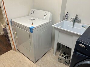 A compact laundry room with a washing machine, a sink, and a small storage bin. - Ravine Villa 4bed 4 bath fully privet (Richmond Hill)