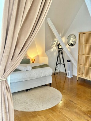 A bedroom with a bed, bedside lamp, and a circular rug.