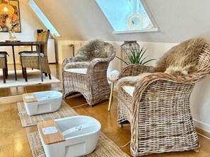 A cozy room with wicker furniture, a white bathtub, and a skylight. - Holiday apartment in heart of Møn (Stege)