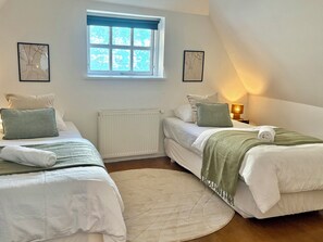 A bedroom with two single beds, a radiator, a window with a view, and a bedside lamp. - Holiday apartment in heart of Møn (Stege)