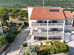 A two-story building with a tiled roof, balconies, and solar panels. - Apartment Stina by Interhome (Novi Vinodolski)