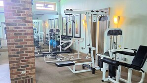 A gym with exercise equipment, a brick pillar, and a ceiling fan. - Downtown Loft w/ Pool, Gym & Parking - Walk to Sundance Square (Fort Worth)
