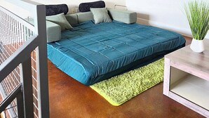 A bedroom with a bed, a ceiling fan, a green rug, and a potted plant. - Downtown Loft w/ Pool, Gym & Parking - Walk to Sundance Square (Fort Worth)