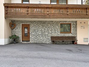 Ein Gebäude mit einer Steinfassade, einer Holztür, einer Bank und einer herzförmigen Dekoration.