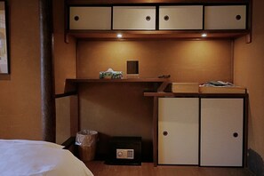 A compact hotel room with a bed, a small desk with a computer, a cabinet with a mirror, and a trash bin. - Kyo-ikkenmachiya Satoi Itoyufu (Kyoto)