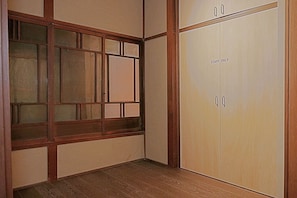 A room with a wooden floor, a sliding door with 'STAFF ONLY' signage, and a window with a grid pattern. - Kyo-ikkenmachiya Satoi Itoyufu (Kyoto)