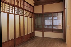 A traditional Japanese room with sliding doors, a wooden floor, and a large window. - Kyo-ikkenmachiya Satoi Itoyufu (Kyoto)