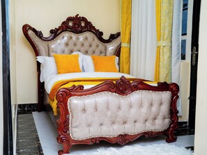 A bed with a tufted headboard, a wooden frame, and two pillows.