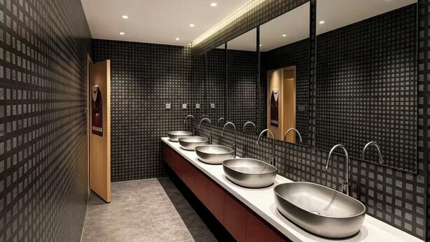 Un baño moderno con un tocador amplio, varios lavamanos y un espejo grande.
