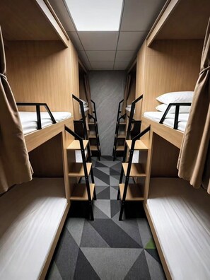 A compact room with bunk beds, a geometric patterned floor, and a skylight.