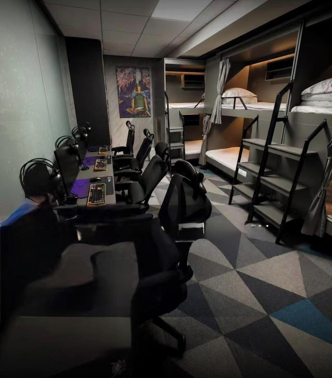 A conference room with a large table, multiple chairs, and a bunk bed in the background.