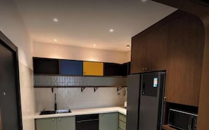 A modern kitchen with built-in appliances, a microwave, and a refrigerator.