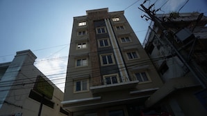 Un immeuble à plusieurs étages doté d’une entrée centrale et d’une enseigne bien visible indiquant qu’il s’agit d’un hôtel.