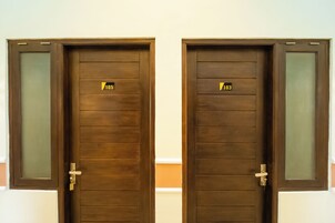 Dos puertas de madera con paneles de vidrio satinado y un mecanismo de cierre.
