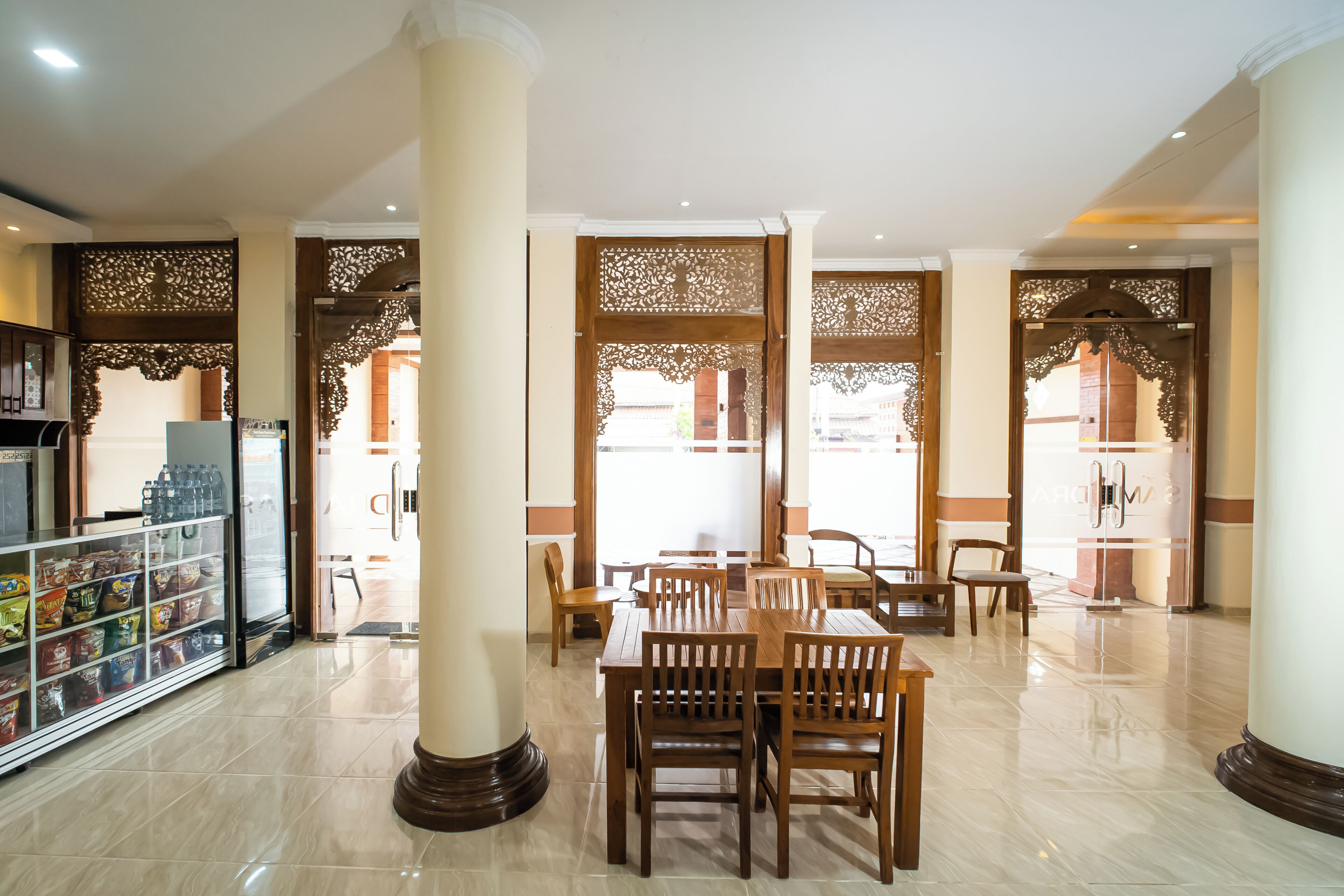 A spacious lobby with a central seating area, a snack bar, and decorative wooden panels.
