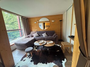 Ein gemütliches Wohnzimmer mit einer Couch, einem runden Couchtisch und einem Cowhide-Teppich.