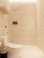 A modern bathroom with a toilet, bidet, and shower.