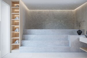 A staircase with a textured wall and a vase on the landing.